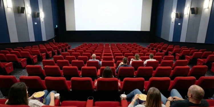 Una sala cinema in Portogallo in crisi perché vi sono poche persone sulle poltroncine rosse. Le pareti sono in stile moderno con colori blu e azzurri e le luci sono accese e sullo schermo non è proiettato il film.