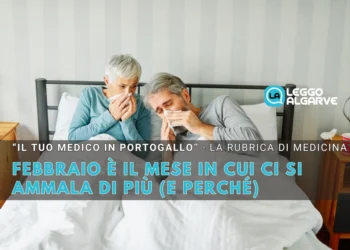 Un uomo e una donna anziani siedono a letto, entrambi con i fazzoletti in mano e dall'aspetto malato. Un testo in italiano spiega perché febbraio ci si ammala più spesso.