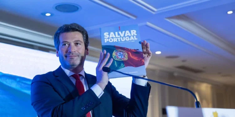 Andre Ventura leader del partito Chega, di cui una petizione per lo scioglimento mostra un libro dal titolo "Salvar Portugal".