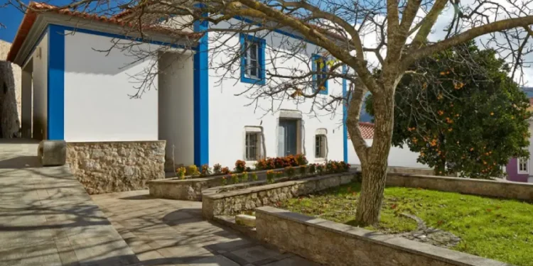 Immagine esterna della Galleria Santo António di Monchique sede dell'esposizione di Vernice Contemporanea dal titolo The Magnificent Four. Si vede una casa tipica dell'Algarve, un piccolo prato con alberi.