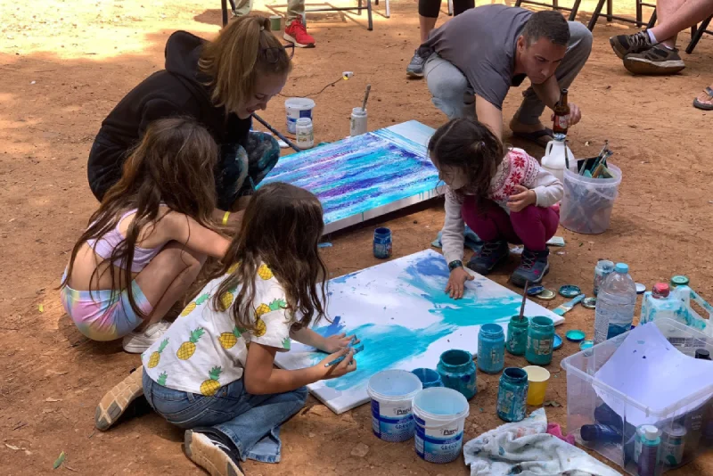 Alcuni bambini a terra pitturano con vernice un opera di arte contemporanea all'interno dell'esposizione The Magnificent Four.