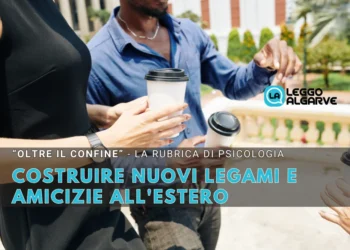 Tre persone in piedi all'aperto con in mano tazze di caffè da asporto, intente a conversare. Un testo in italiano sovrasta l'immagine, promuovendo una rubrica di psicologia su costruire legami all'estero e nuove amicizie.
