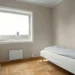 Una camera minimal con pareti beige chiaro, un letto singolo con piumone a pois, una scrivania e una sedia bianche, parquet in legno e un'ampia finestra che lascia entrare la luce naturale: l'ideale per chi vuole affittare stanze Portogallo.