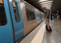 All'interno della stazione della Metro di Lisbona un convoglio è fermo per lavori, mentre un uomo osserva un cellulare in attesa di aggiornamenti.