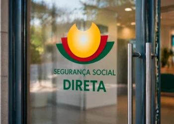 Porta in vetro con il logo e il testo "Segurança Social Direta" in portoghese, caratterizzato da una grafica gialla, rossa e verde. Lo sfondo rivela un interno di ufficio moderno sfocato, che evidenzia la modalità di accesso al sito Seguranca social.